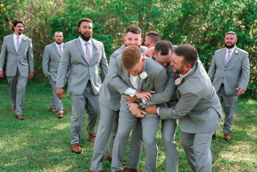 Wedding Photography Tips - groomsmen bear hugging groom