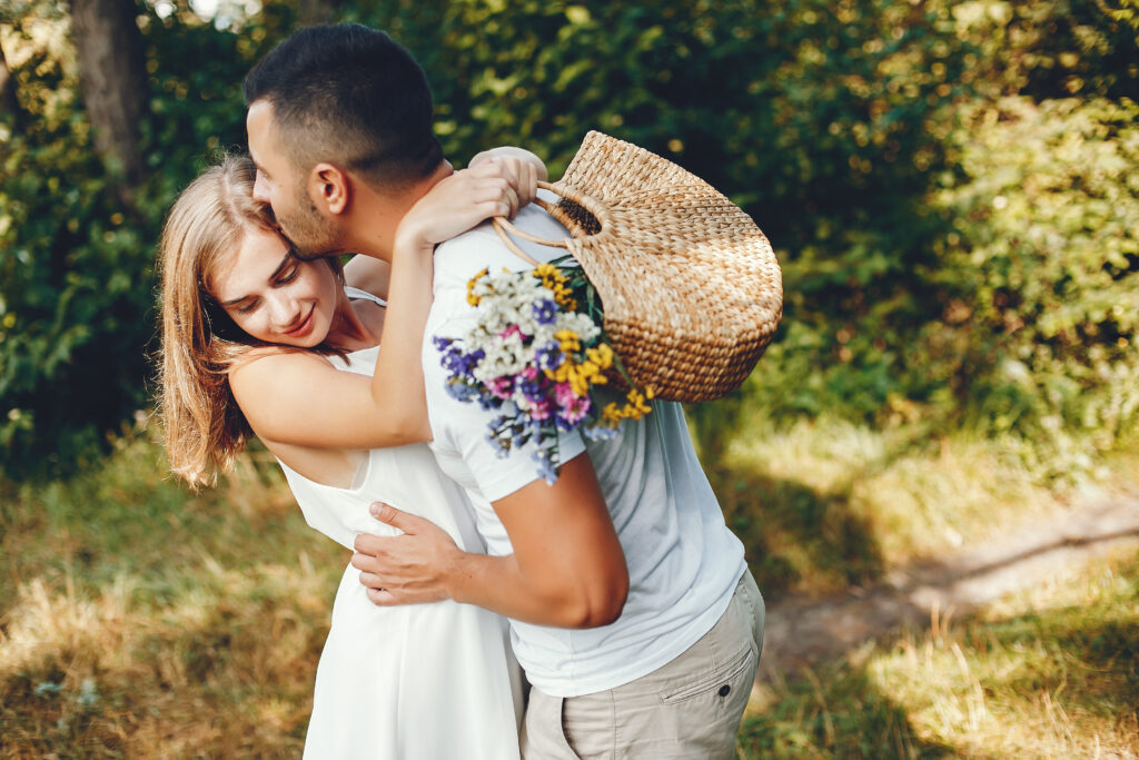 Cute couple in a park. Lady in a white dress. Girl with bouquet of flowers. Seasonal Photo Ideas for Engagement Sessions.