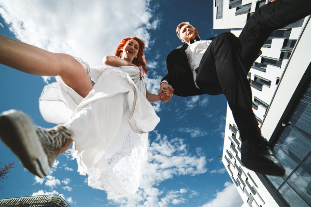 Wedding couple jumping in a futuristic building