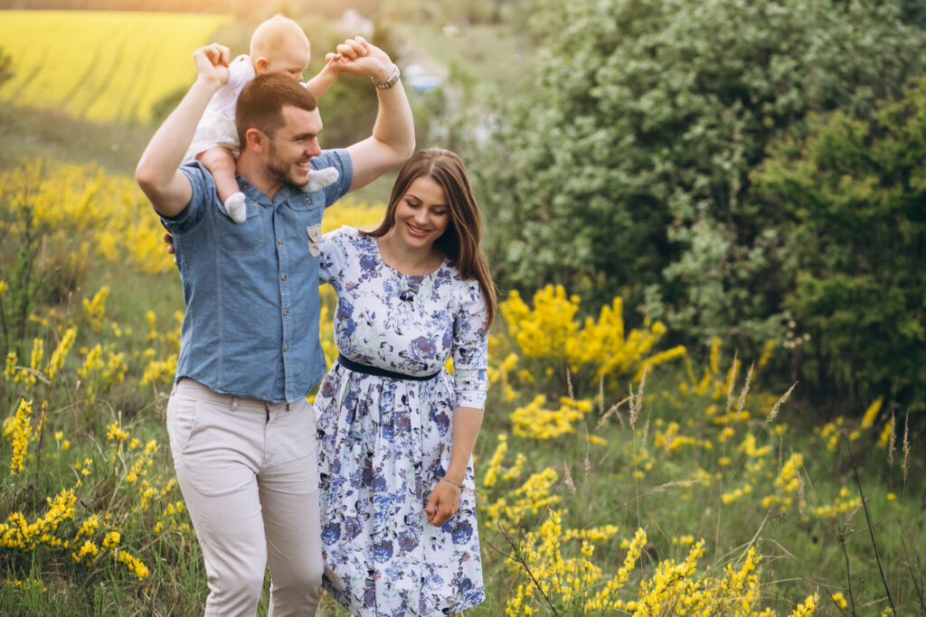 Essential Tips for a Fun and Fabulous Family Photo Session. family in a field with baby on dad's shoulders