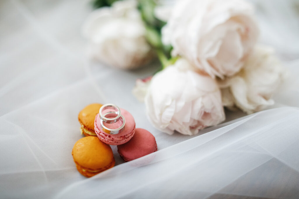 Silver wedding rings lie by white bouquet on the floor. The Latest Photography Trends in Wedding Photography