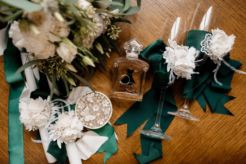 Wedding rings lie on the perfumes near other decor