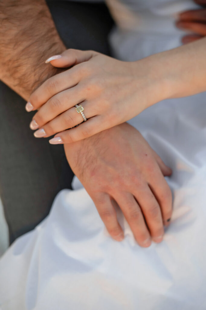 close up of engagement ring and hands