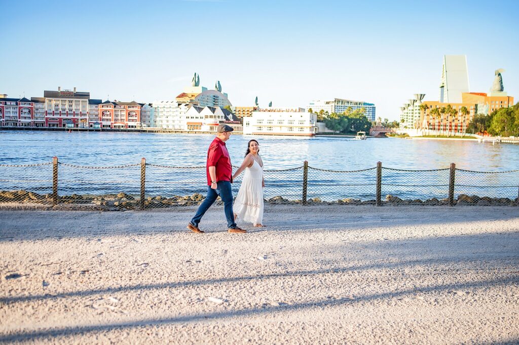 couple walking hand and hand in the sand at disney's boardwalk