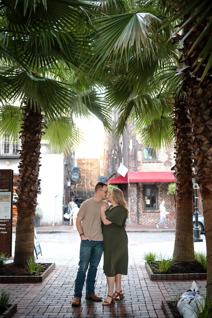 couple looking at each other underneath palm trees