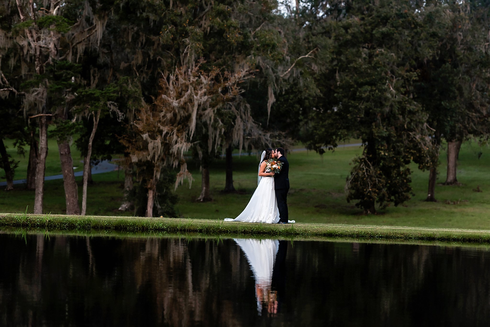 bride and groom in front of lake reflection photo